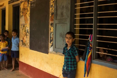 Akash is 7 years old (hearing and speech impaired). He regularly visits the school with his brother who is one year older, studying in third standard.
"Akash stands like this outside or he takes a few steps to the front, and then back without leaving his brother's class room. He never tried sitting inside the classroom", the HM of that school, one of the two teachers there, told.
That single class room (of Akash's brother's) accommodates students of classes 1,2 & 3. The next classroom handles students from 4th & 5th.
Akash's mother is a nurse.