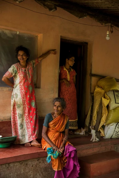 The woman who is sitting is Girija and she was widowed years ago. On her left and right are her daughters Revathy and Jayanti, respectively. They have an elder brother Harish who is a farmer, assisted by them and their mother. They own half an acre of paddy field and a house.None of Girija's children are married yet. Taken from Badakodi, Belthangady taluk. Karnataka.