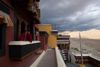 Thang Syng and Lurbu,  secretly passing  comments on potbellied Indian tourists, who are climbing stairs that lead  to them, 11800 ft above. At Thiksey Monastery, Leh district, Ladakh.
