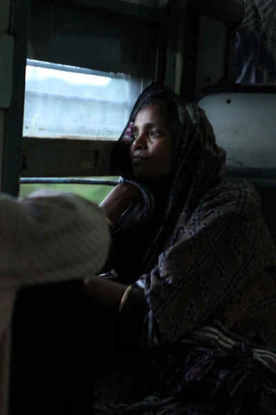 A woman goes back home in a local compartment of a train after work. Take from Odisha 